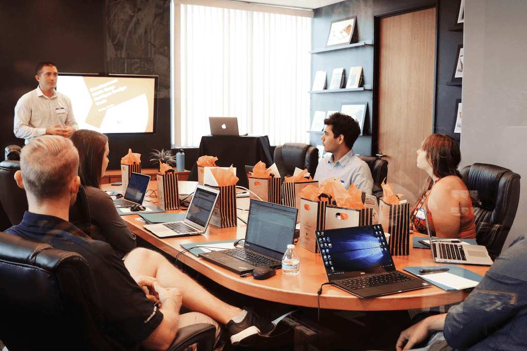 Strategic consulting team collaborating around conference table with laptops and business documents